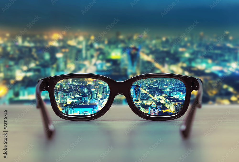 Night cityscape focused in glasses lenses - obrazy, fototapety, plakaty 