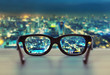 canvas print picture - Night cityscape focused in glasses lenses