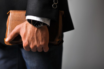 A businessman in a suit and jeans holding book