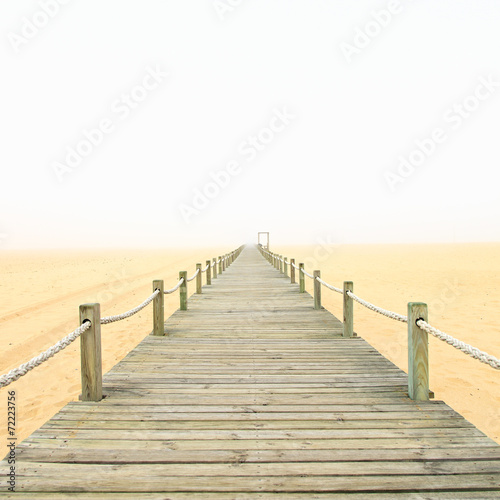 drewniany-footbridge-na-mglowym-piasek-plazy-tle-portugalia