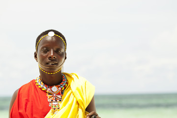 young massai warrior man posing on bright sunny beach in kenya