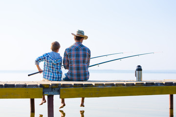 boy and his father fishing togethe