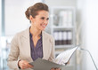 Happy business woman with documents in office