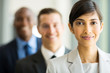 © michaeljung - indian businesswoman standing in a row with colleagues