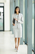 © michaeljung - young indian office worker holding a clipboard and walking in of