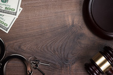 Handcuffs Gavel And Money On Wooden Background
