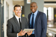© michaeljung - two businessmen using tablet pc