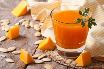 Wall Mural - The useful juice of ripe pumpkin close-up on the table