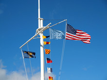 Nautical And American Flags Hanging From A Ship's Mast With Wisp