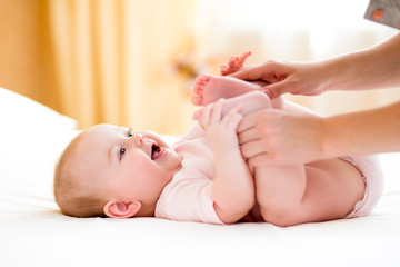 Wall Mural - mother massaging or doing gymnastics baby girl