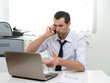 © Studio Gi - Businessman with laptop talking on the phone, selective focus