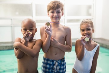 Cute swimming class smiling with medals