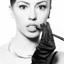 Audrey Hepburn Style Concept. Fashionable Model Smoking