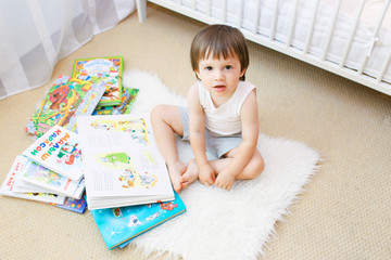 2 years toddler with books in his room