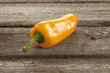 Yellow sweet pepper on a rough wood surface