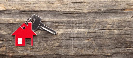 symbol of the house with silver key on vintage wooden background