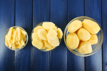 Wall Mural - Raw peeled and sliced potatoes in glass bowls