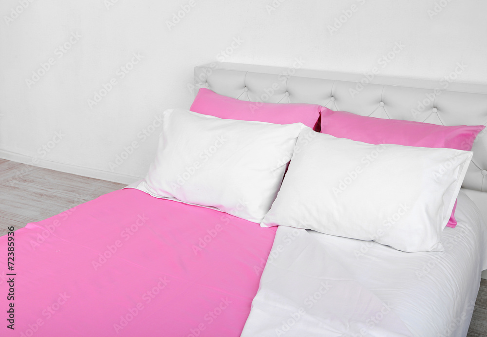 Bed in pink bed linen in room