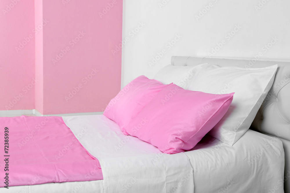 Bed in pink bed linen in room