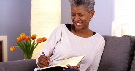 Mature black woman writing in journal