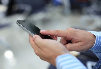 Wall Mural - Close up of a business man using mobile smart phone