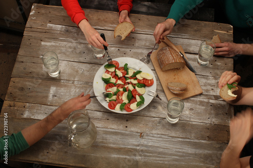 Valokuva Eating caprese salad with friends, top view