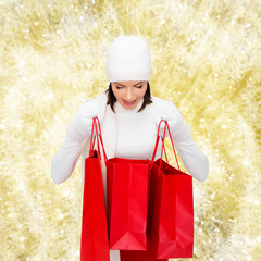 Canvas Print - smiling young woman with red shopping bags