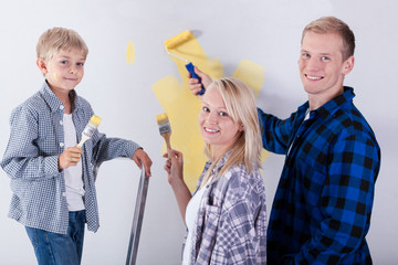 Family painting wall in new house