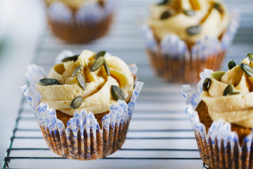 Pumpkin cupcake with buttercream and pumpkin seeds, close-up