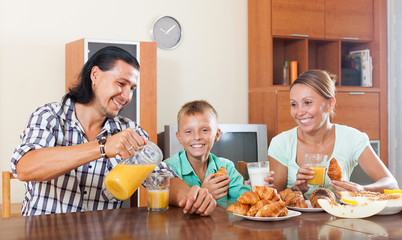 Wall Mural - family having breakfast with oranges juice in morning