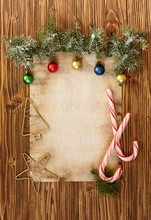 Christmas Decorations On The Old Sheet Of Paper On A Wooden Back
