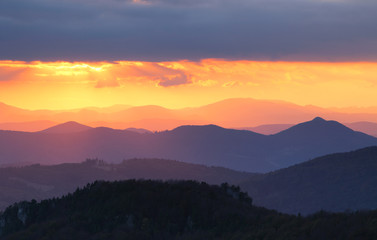 Sunset over color mountain silhouette.