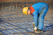 Builder making reinforcement for concrete