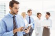 © WavebreakmediaMicro - Businessman using digital tablet with colleagues behind