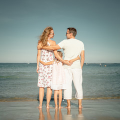 Happy family standing at the beach at the day time