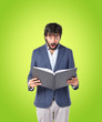 © luismolinero - Surprised man reading a book over green background
