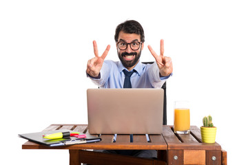 Wall Mural - Businessman in his office doing victory gesture