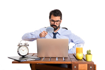 Wall Mural - Businessman in his office with magnifying glass