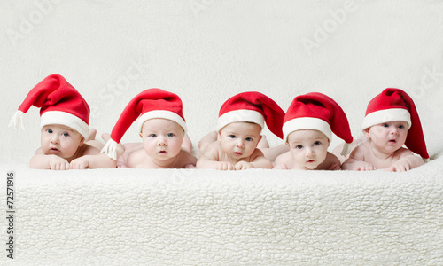 Fotografía babies with santa hats on bright background
