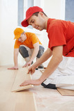 Fototapeta  - parquet workers at flooring work