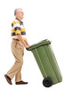 Senior pushing a large green trash can
