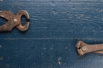 Poster - old rusty tongs on blue table