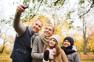 Canvas Print - happy family with camera in autumn park