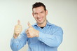 © petrdlouhy - Handsome smiling man in blue shirt shows you thumbs up