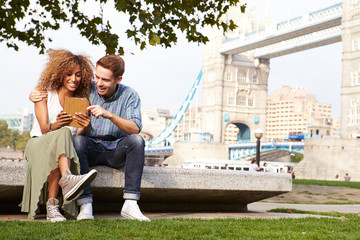 Wall Mural - Couple Using Digital Tablet With Tower Bridge In Background