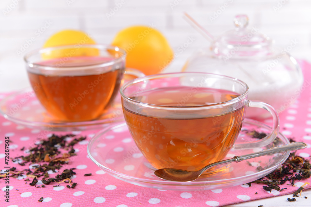 Cups of tea on table on brick wall background