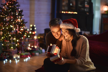 Wall Mural - portrait of a young couple in their living room at christmas eve