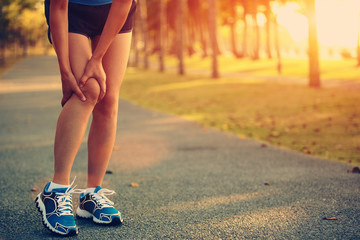 Poster - woman runner hold her sports injured knee 