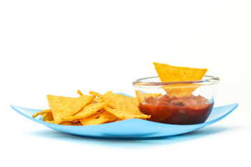 Tortilla chips with salsa sauce in dish on white background