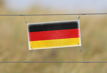 Border fence - Old plastic sign with a flag